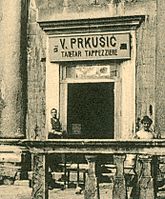 Un'insegna bilingue all'interno del palazzo di Diocleziano: "V. Prkušić Tapetar – Tappezziere"