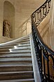 Des escaliers au Collège des Bernardins à Paris, une statue sans tête se trouve dans une niche.