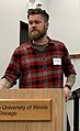 Image 101American man wearing a slim-fitting flannel shirt, a beard, and an undercut, 2019. Sleeve tattoos can be seen. (from 2010s in fashion)