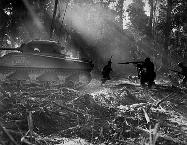 United States infantrymen clearing out Japanese infiltrators on Bougainville in the cover of an M4 Sherman, March 1944.