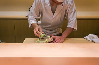 A chef grating fresh wasabi root