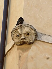 Masque de théâtre du théâtre de Pompée en remploi sur un mur d'angle de la piazza Pollarola.