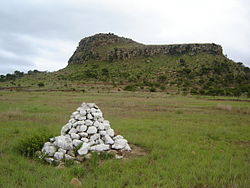 V pozadí hora Isandlwana, v popředí kamenná mohyla na hrobě britských vojáků