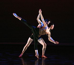Dance partnering – a male dancer assists a female dancer in performing an arabesque, as part of a classical pas de deux