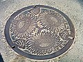Manhole cover depicting sunflowers, a symbol of Zama