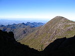 Vista Sul do Parque Nacional do Caparaó. Fotografia tirada da trilha de acesso ao Pico da Bandeira. À direita e próximo, vê-se o Pico do Calçado, ao fundo aparece a Pedra Menina.