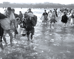 중공군의 개입으로 신발을 벗어들고 얼음 조각이 떠 다니는 대동강을 건너 남하하는 피난민들: 1950년 12월 13일