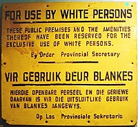 Sign reading "For use by white persons. These public premises and the amenities thereof have been reserved for the exclusive use of white persons." with translation in Afrikaans.