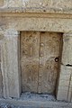 Porta in pietra spessa all'ingresso della catacomba, realizzata come replica della porta in legno sbalzato