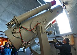 Il telescopio Schmidt da 77 cm. In origine utilizzava una pellicola fotografica, mostrata nella foto dall'addetto