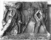 Image d'une sculpture en bas relief sur marbre montrant sur la partie gauche un homme âgé auréolé, drapé dans une longue tunique chassant d'un geste, au centre un homme nu de dos et à droite une femme nue de profil qui s'éloigne.