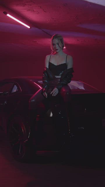 Stylish woman sitting on a Camaro.