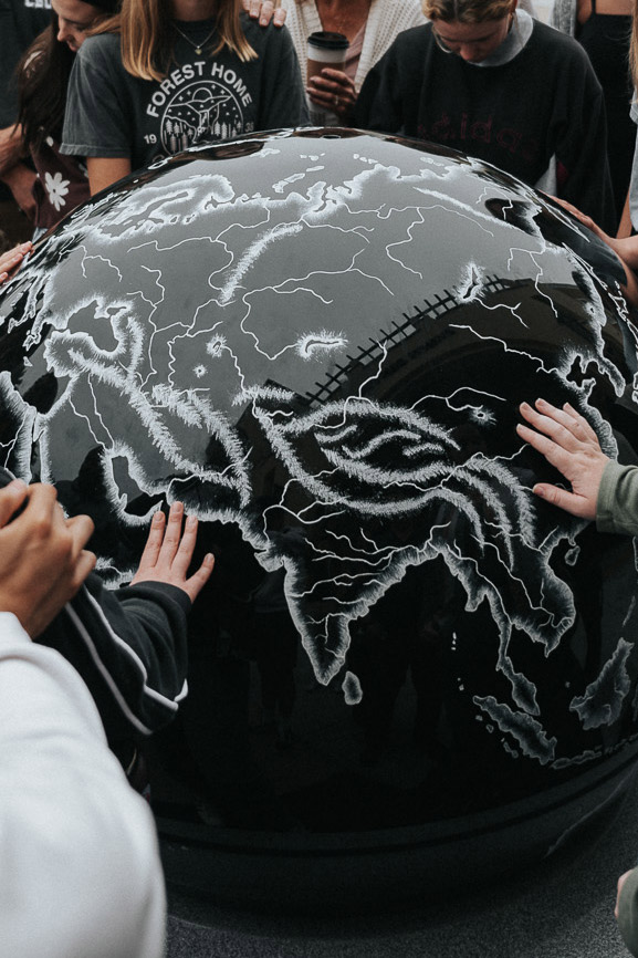 Students praying next to the CBU kugel